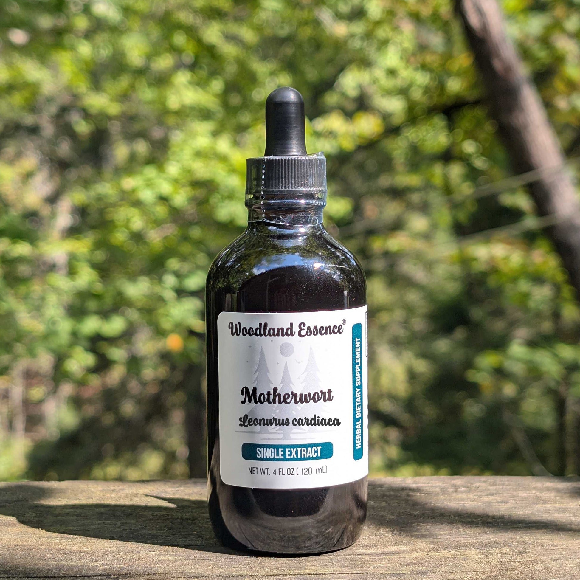 Bottle of Woodland Essence Motherwort extract on a wooden surface with a blurred natural background