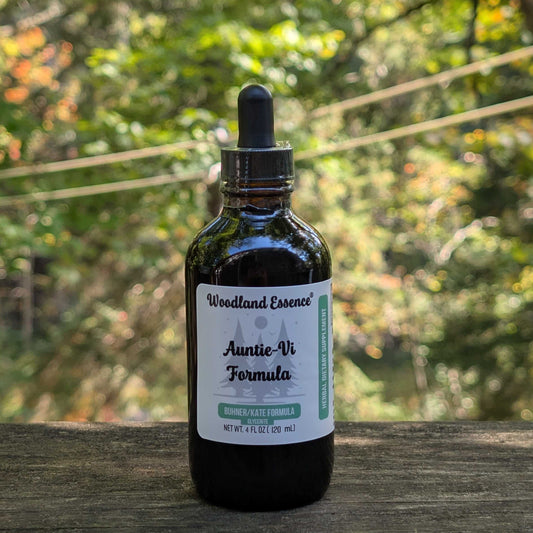 Bottle of Woodland Essence Auntie-Vi Formula on a wooden surface with a blurred natural background