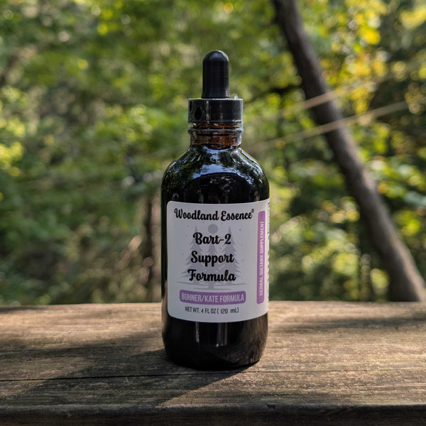 Bottle of Woodland Essence Bart-2 Support Formula on a wooden surface with a natural background