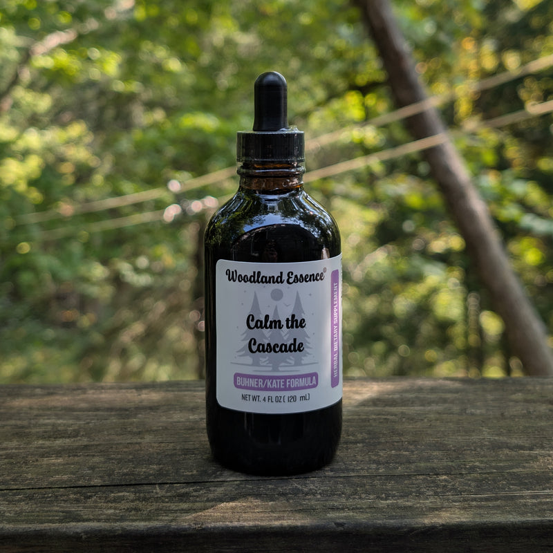 Bottle of Woodland Essence Calm the Cascade on a wooden surface with a blurred natural background
