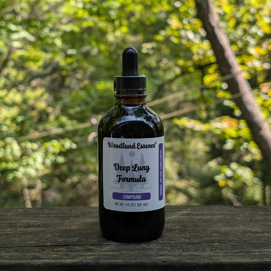 Bottle of 'Woodland Essence Deep Lung Formula' on a wooden surface with a blurred natural background