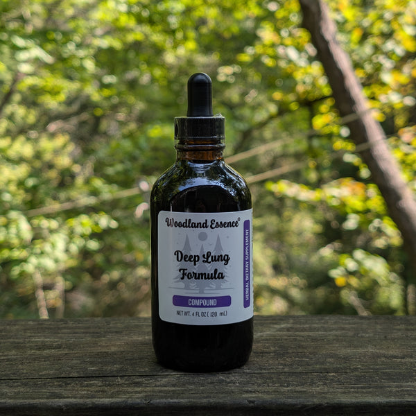 Bottle of 'Woodland Essence Deep Lung Formula' on a wooden surface with a blurred natural background