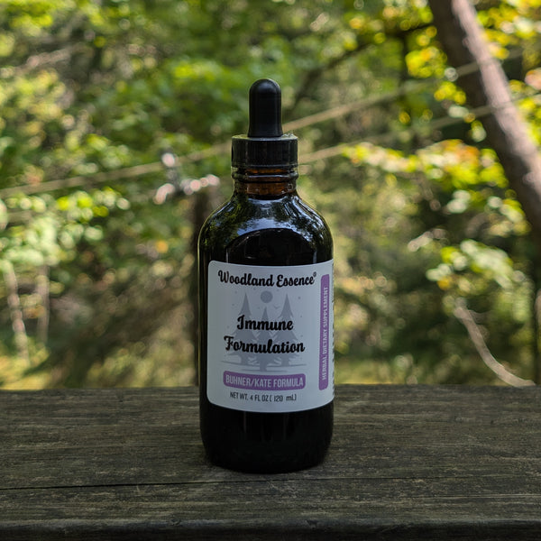 Bottle of Woodland Essence Immune Formulation on a wooden surface with a natural background