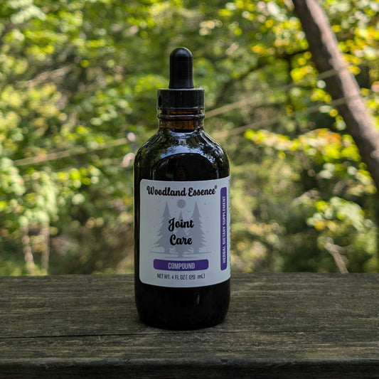 Bottle of Woodland Essence Joint Care Compound on a wooden surface with a natural background