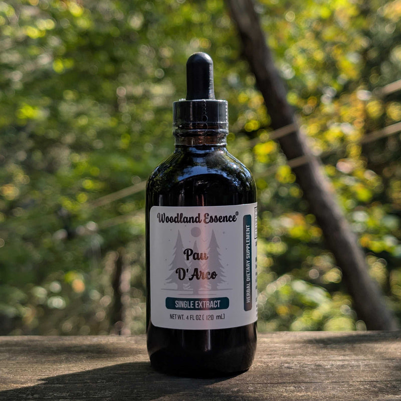 Bottle of Woodland Essence Pau D'Arco extract on a wooden surface with a blurred natural background