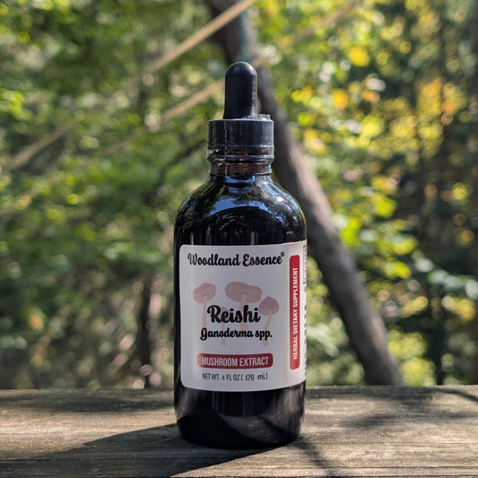 Bottle of Woodland Essence Reishi Ganoderma spp. Mushroom Extract on a wooden surface with a blurred natural background