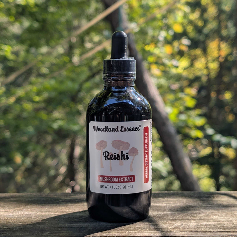 Bottle of Woodland Essence Reishi mushroom extract on a wooden surface with a forest background