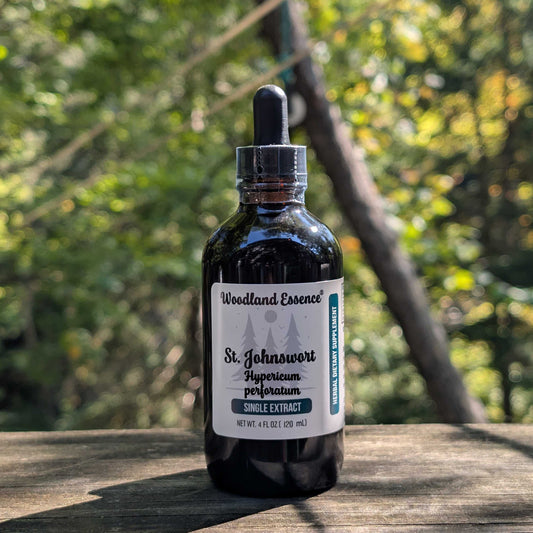 Bottle of Woodland Essence St. Johnswort extract on a wooden surface with a natural background