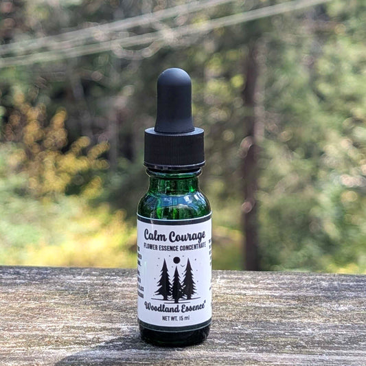 bottle of calm courage fe on wooden ledge with forest background 