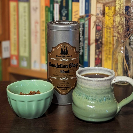Dandelion Chaga Blend canister with a mug and small bowl on a wooden surface, with books in the background.