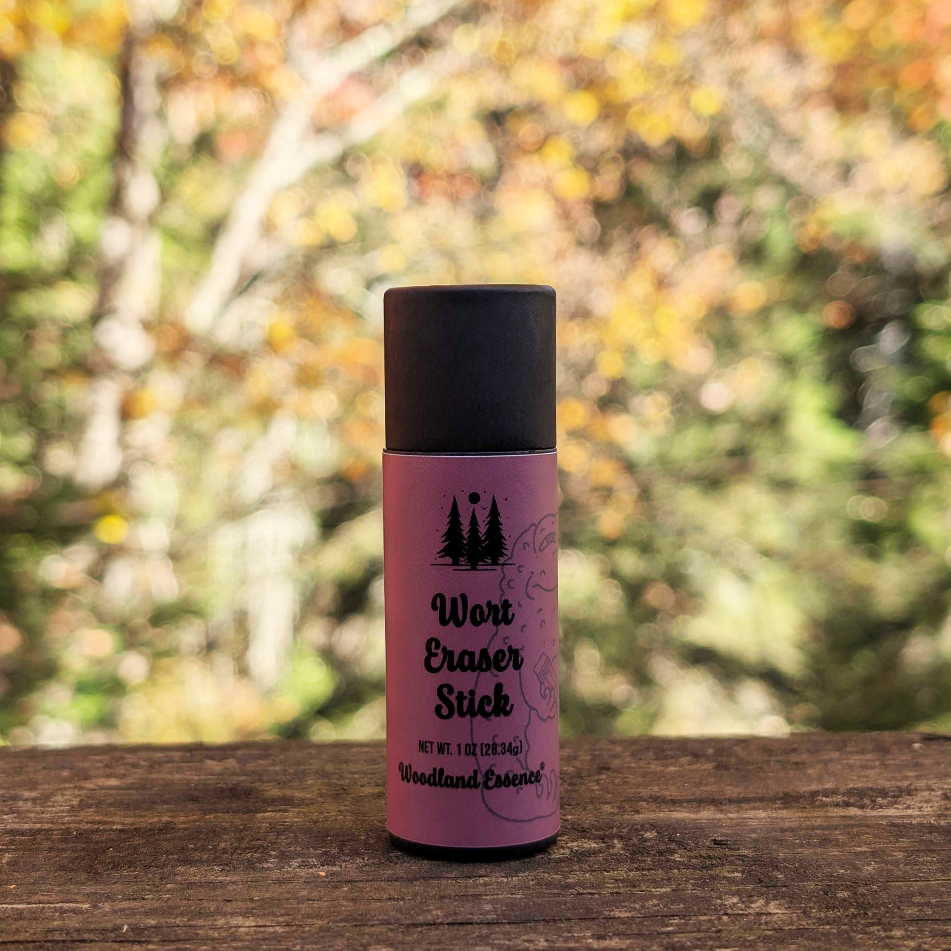 Purple and black bottle labeled 'Wort Eraser Stick' on a wooden surface with a blurred natural background