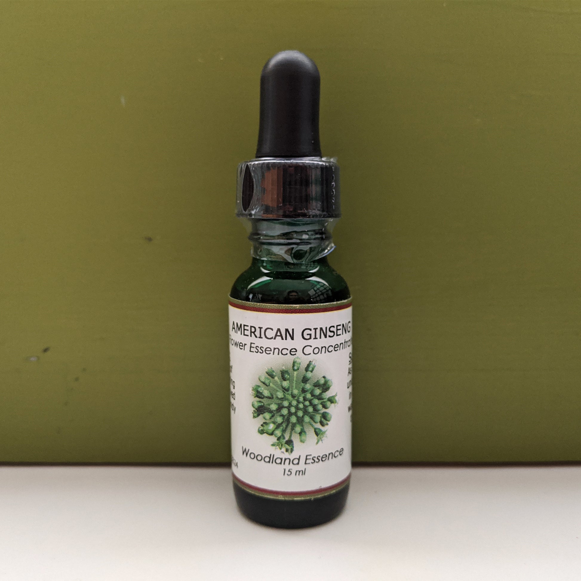 American Ginseng Flower Essence bottle against green back drop 
