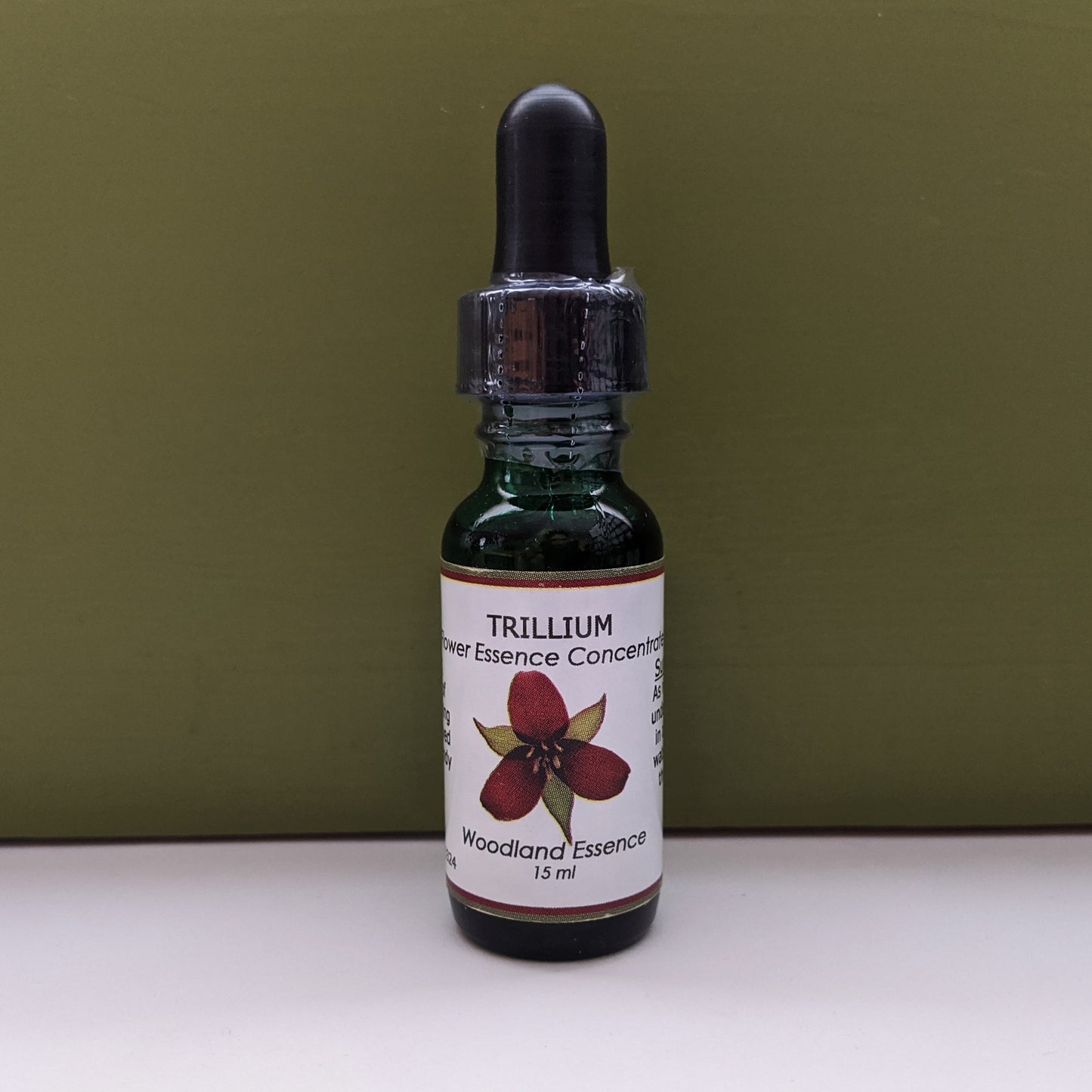 Bottle of Trillium Flower Essence against green background 
